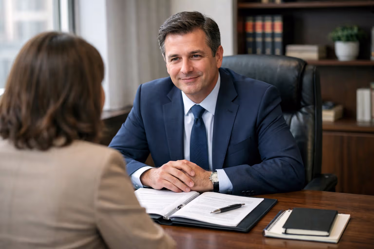 Attorney consulting with a client across a desk with legal documents during a wrongful death case evaluation meeting