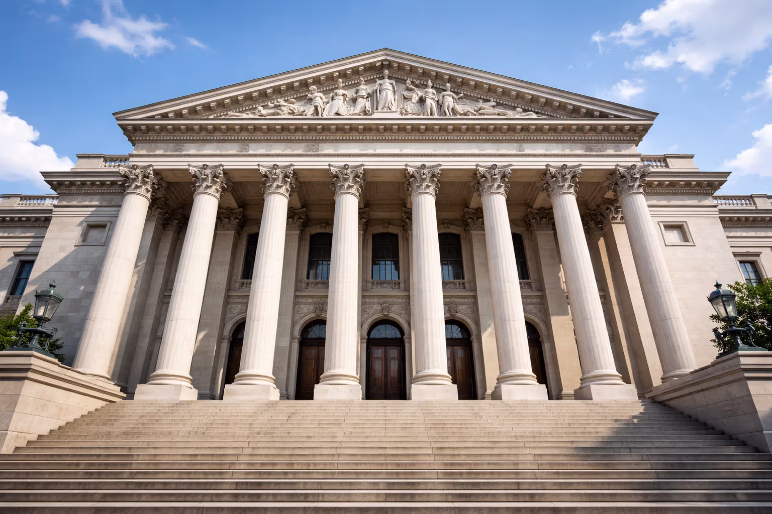 Classical courthouse building facade with stone columns and steps under clear sky